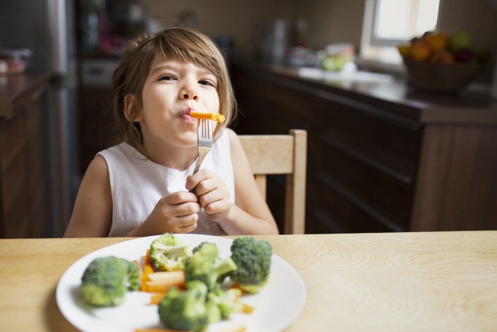 front view baby girl having vegetables