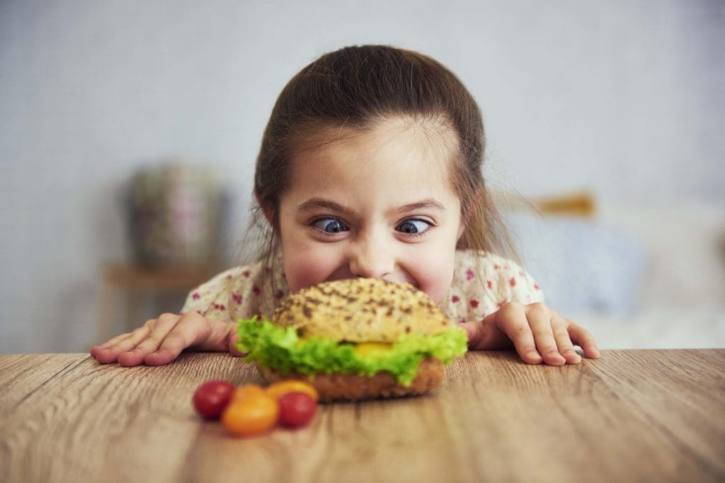 playful girl looking delicious hamburger