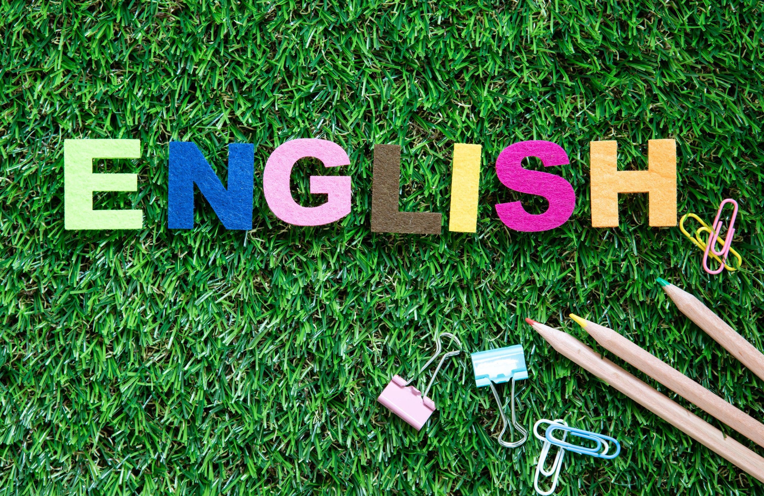 colorful ENGLISH word cube on green grass yard  background ,Engl